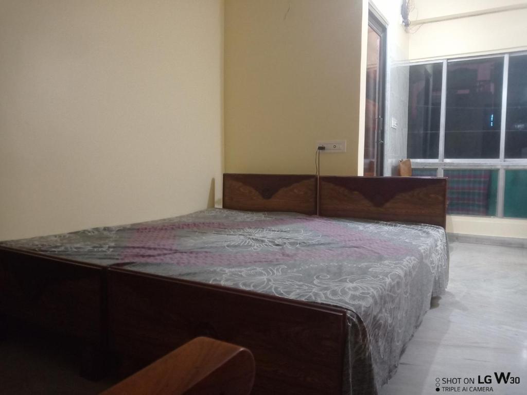 uma cama num quarto com uma grande janela em The Tulip Touch for Couples. em Calcutá