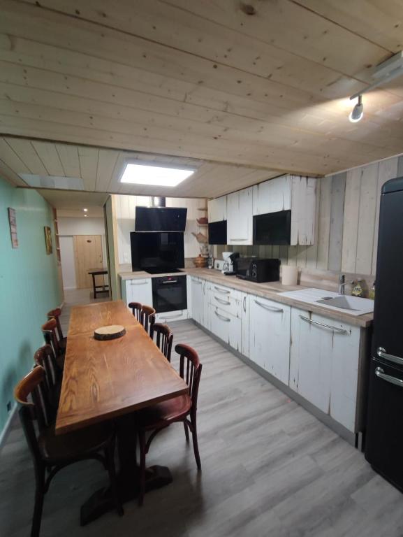 une grande cuisine avec une table et des chaises en bois dans l'établissement Residence l'Oncet - Appartement 8 personnes, à Barèges