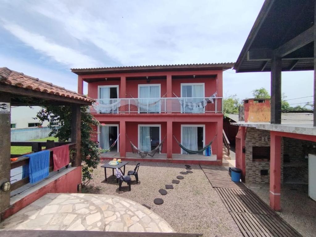 una casa roja con balcón frente a ella en Pousada dos Pinheiros, en Guaraqueçaba