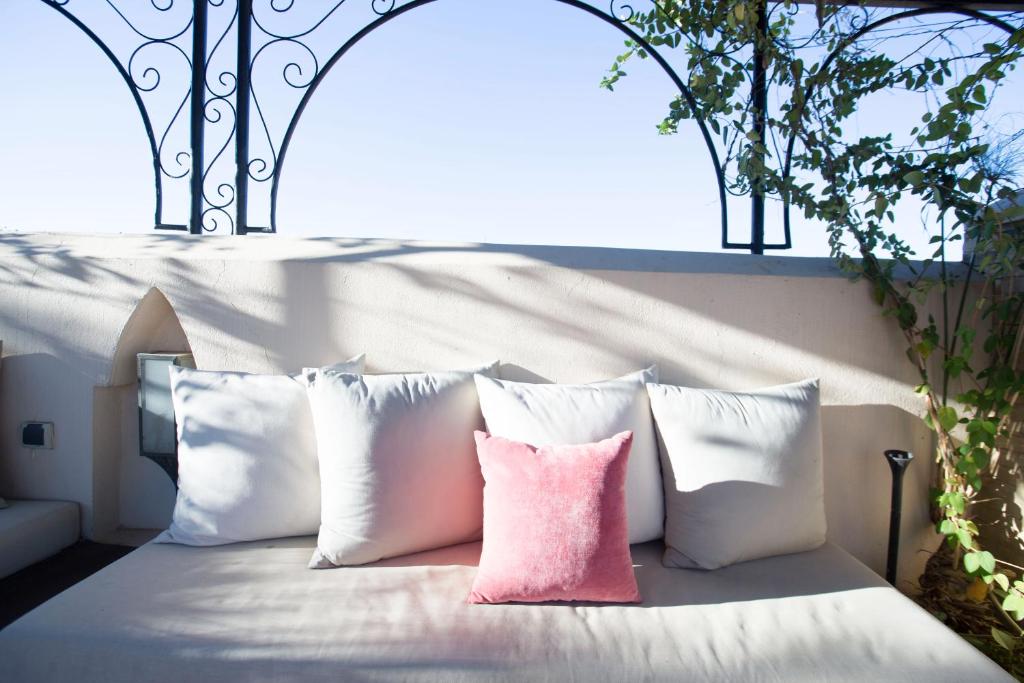 a bed with white pillows and a pink pillow at Riad Fes Kettani in Fez