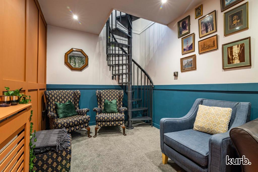 a living room with two chairs and a staircase at The Church House - 3 Bedroom House + Free Parking in Nottingham