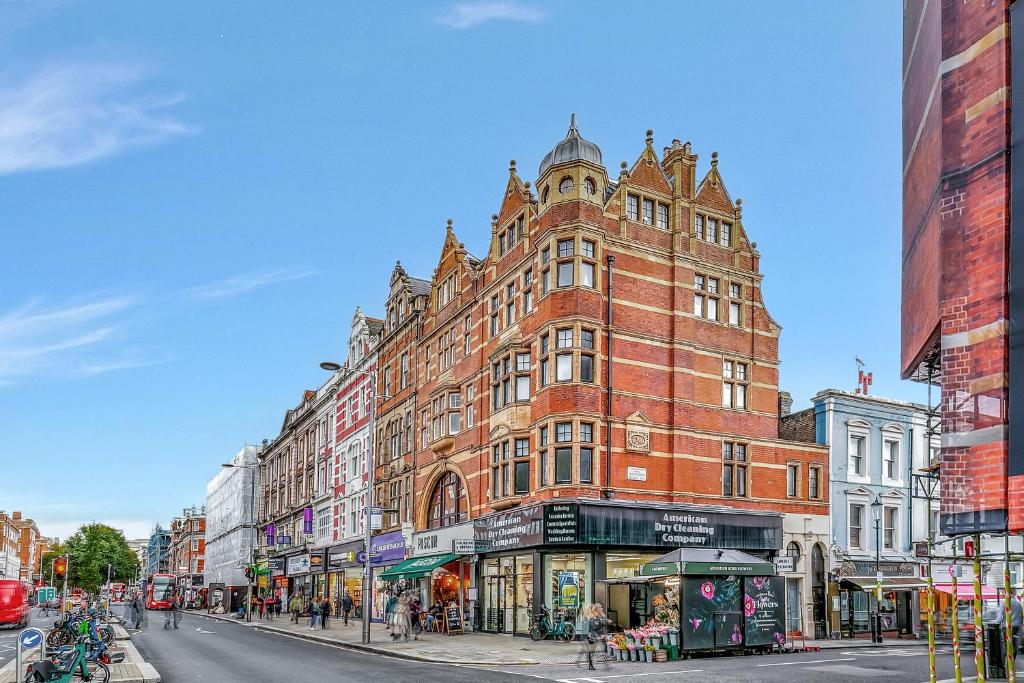 a large red brick building on a city street at Lovely Kensington Apartments in London