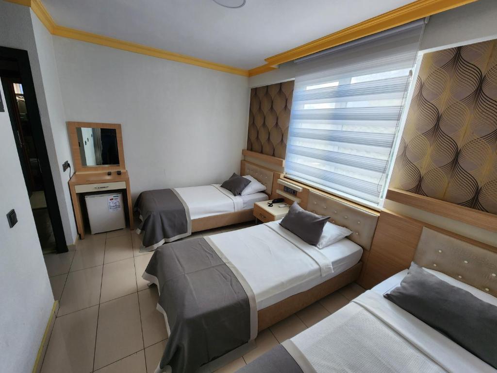 Habitación de hotel con 2 camas y ventana en ANTALYA Konyaaltı Gündüz Otel, en Antalya