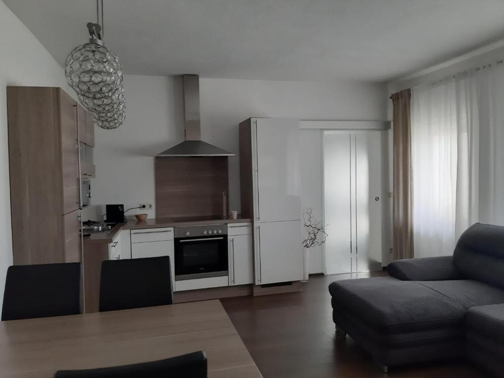 a living room with a couch and a kitchen at Ferienwohnung Leithaberg in Eisenstadt