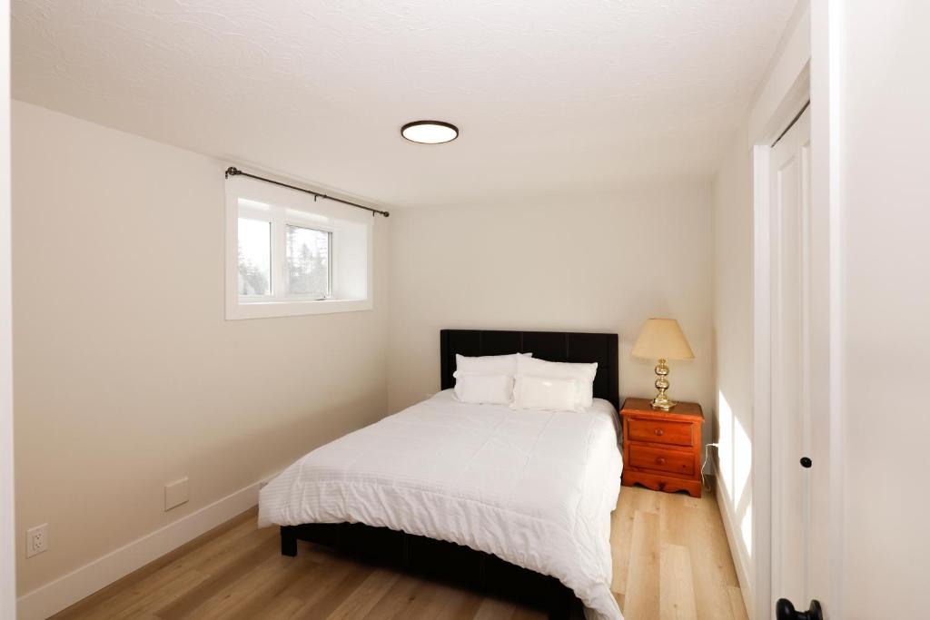 モンクトンにあるLuxury Vacation Spaceの白いベッドルーム(ベッド1台、窓付)