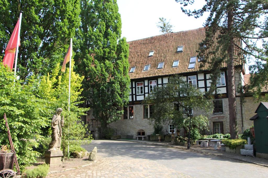 ein Gebäude mit Flaggen und einer Statue davor in der Unterkunft Hotel Altes Rittergut in Sehnde
