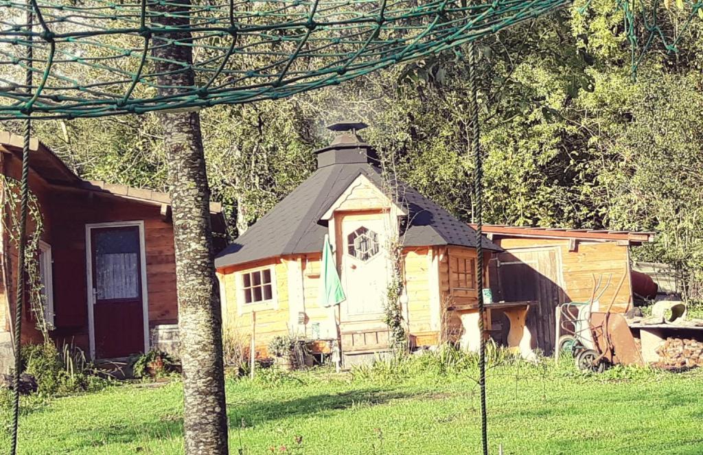 a small house with a black roof in a yard at Private Lakeside Retreat in Renac