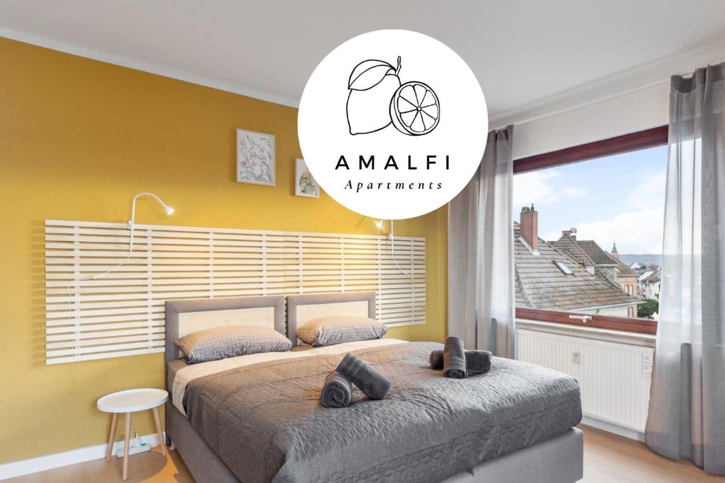 1 dormitorio con cama y pared amarilla en Amalfi Apartment A03 - 3 Zi.+ bequeme Boxspringbetten + smart TV, en Eltville am Rhein