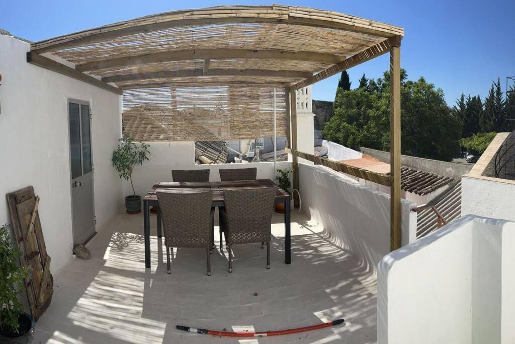 a patio with a table and chairs under a pergola at Casa Porta Velha 2 Bed in Tavira