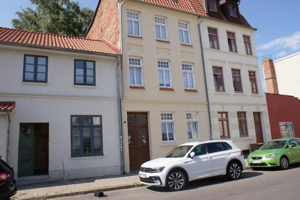 a white car parked in front of a building at Altstadtappartement - ABC59 in Wismar