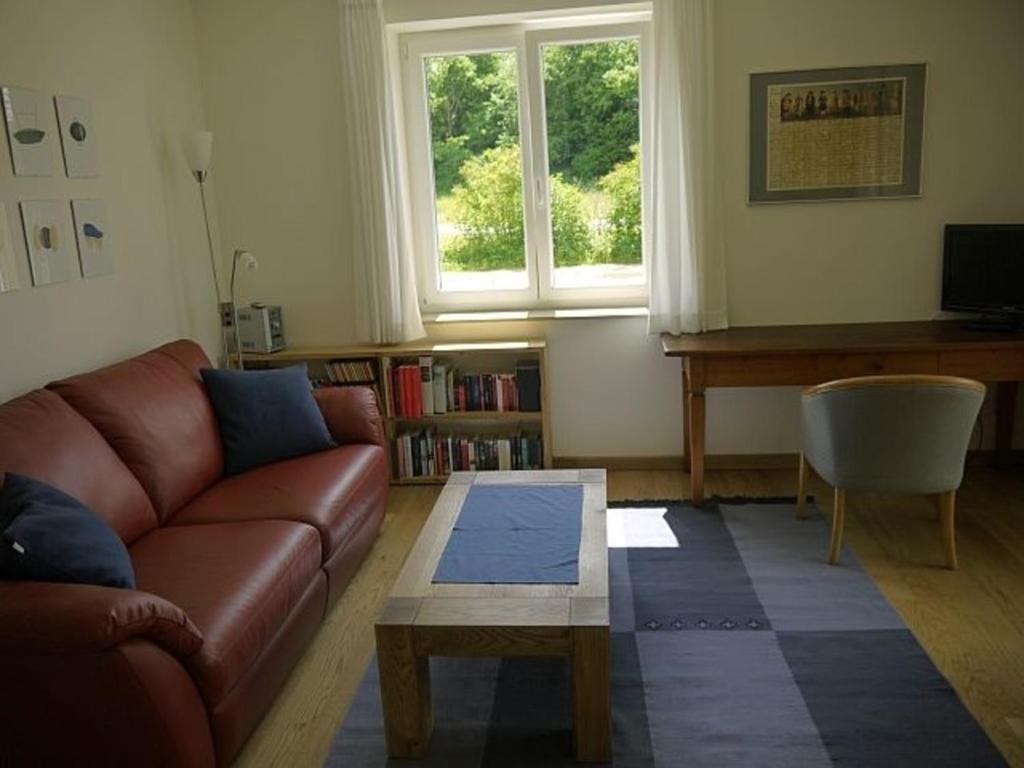 een woonkamer met een bank, een tafel en een raam bij Ferienwohnung Axeli Knapp in Schleswig