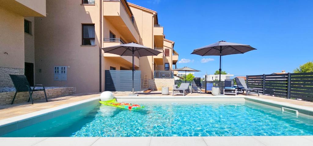a pool with a toy in the water in front of a building at Apartment Bluemare B6 with Shared Pool in Ližnjan
