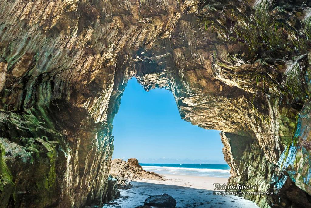 a view of a rock cliff next to a beach at Pousada e Camping do Clodo in Ilha do Mel