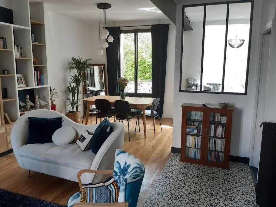 un salon avec un canapé blanc et une table dans l'établissement Maison - 12 min Paris Saint-Lazare, à Colombes