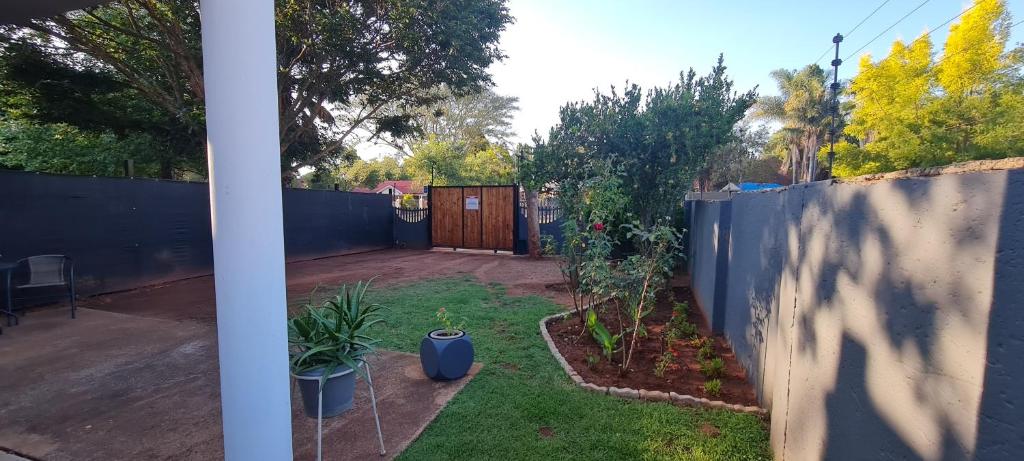 a backyard with a fence and a yard with plants at Tenuta Overnight in Polokwane