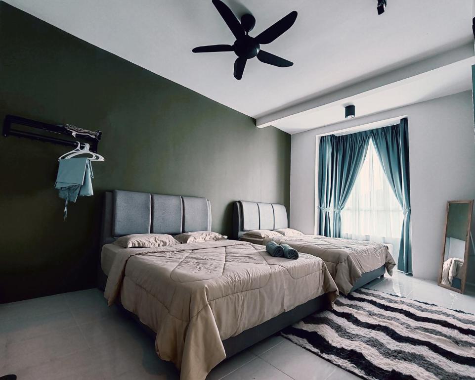 a bedroom with two beds and a ceiling fan at D'Elegant Suite - Emerald Avenue in Cameron Highlands