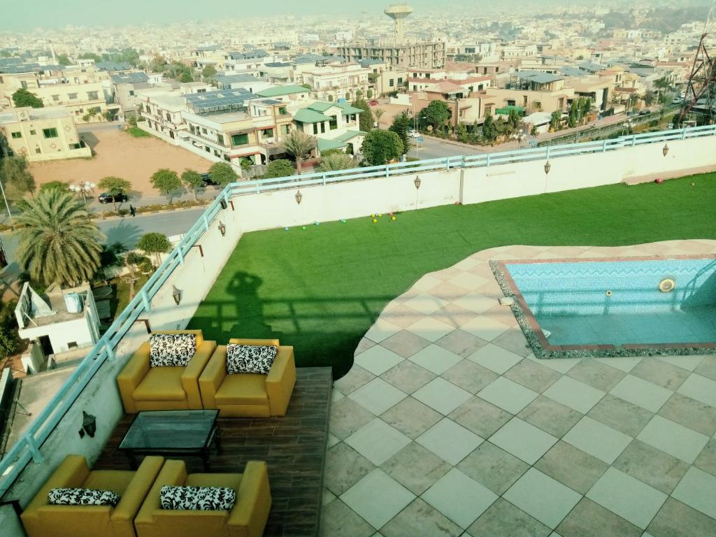 een balkon met 2 banken en een zwembad bij Comfortable Rental Apartments In Bahria Town in Rawalpindi