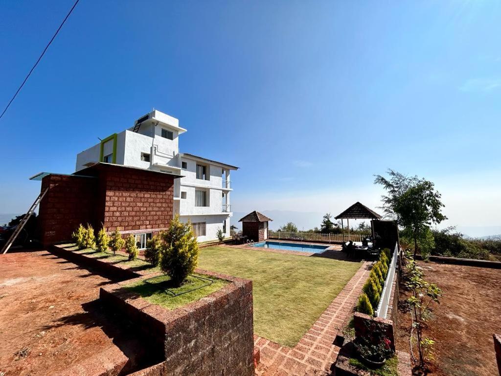 a house with a swimming pool in front of it at Konark Villa in Mahabaleshwar