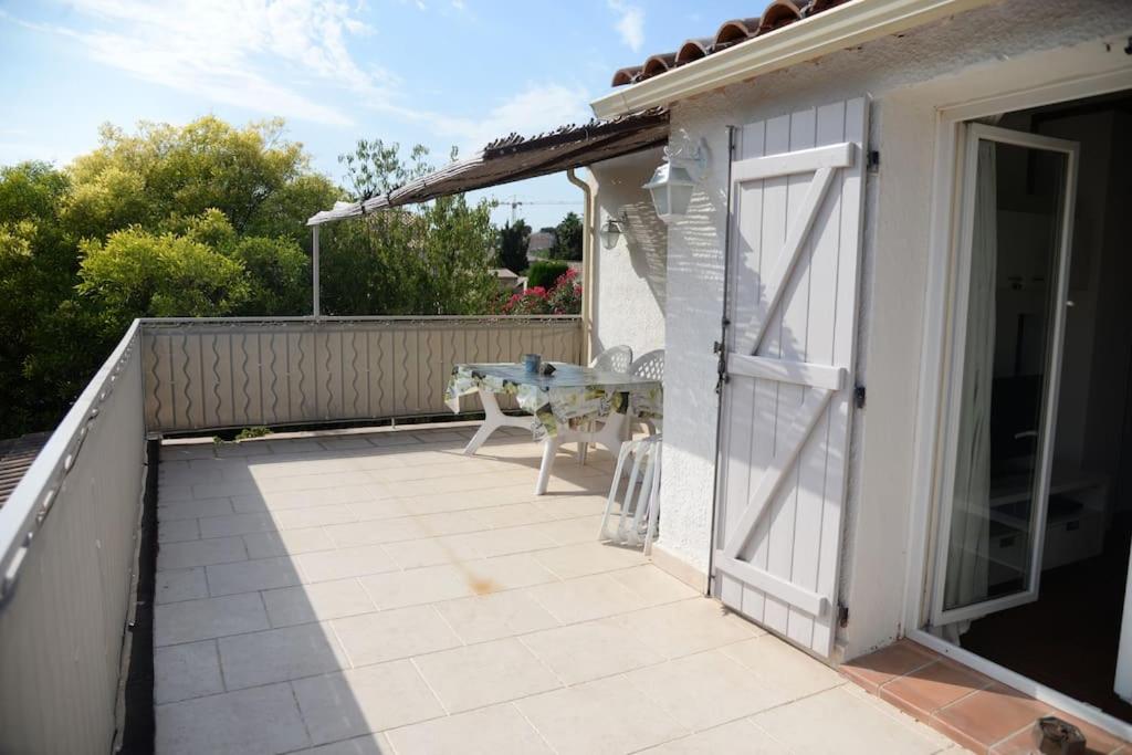 an open door to a patio with a table on a balcony at Bel Appartement En Haut de Villa in Sanary-sur-Mer