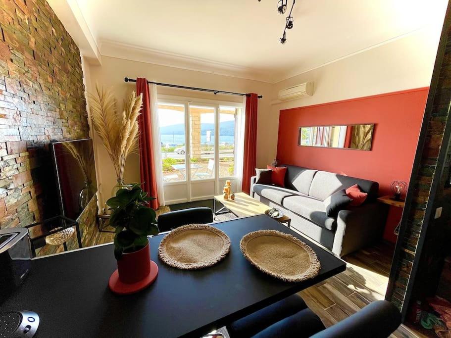 uma sala de estar com uma mesa com dois pratos em Appartement Propriano Corse du Sud Face à la Mer em Propriano
