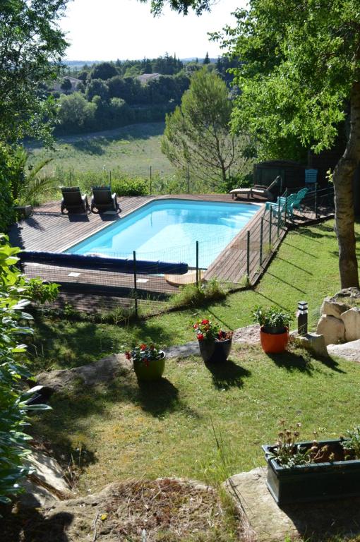 einen Pool in einem Garten mit Topfpflanzen in der Unterkunft Chalet, calme, absolu, superbe vue, et piscine (en été) in Ventenac-Cabardès
