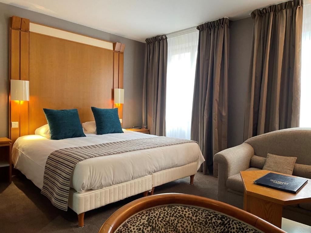 une chambre d'hôtel avec un lit et une chaise dans l'établissement Hôtel EUROPE, à Saverne