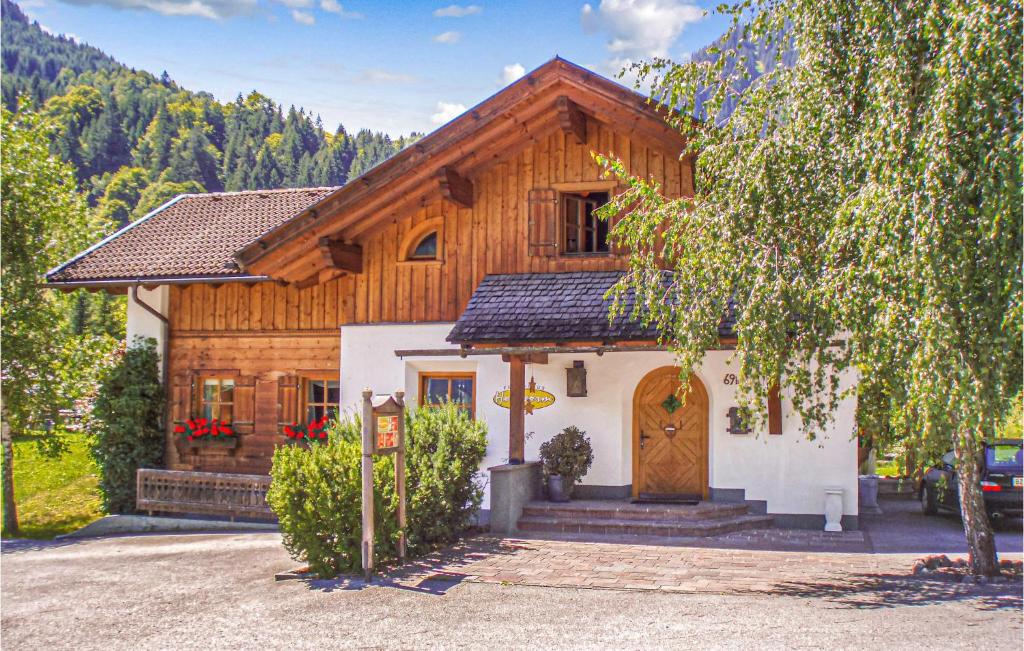 una casa en las montañas con un árbol en Haus Holzworm, en Aussersiggam