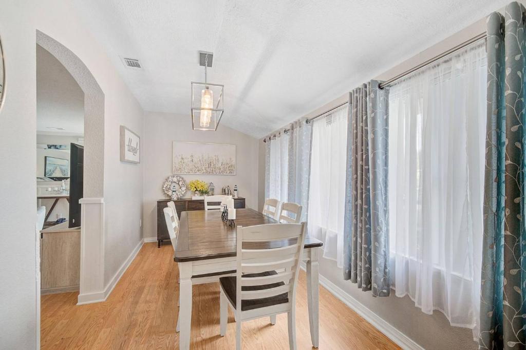 a dining room with a table and chairs next to a window at Palm Tree Paradise in Bradenton