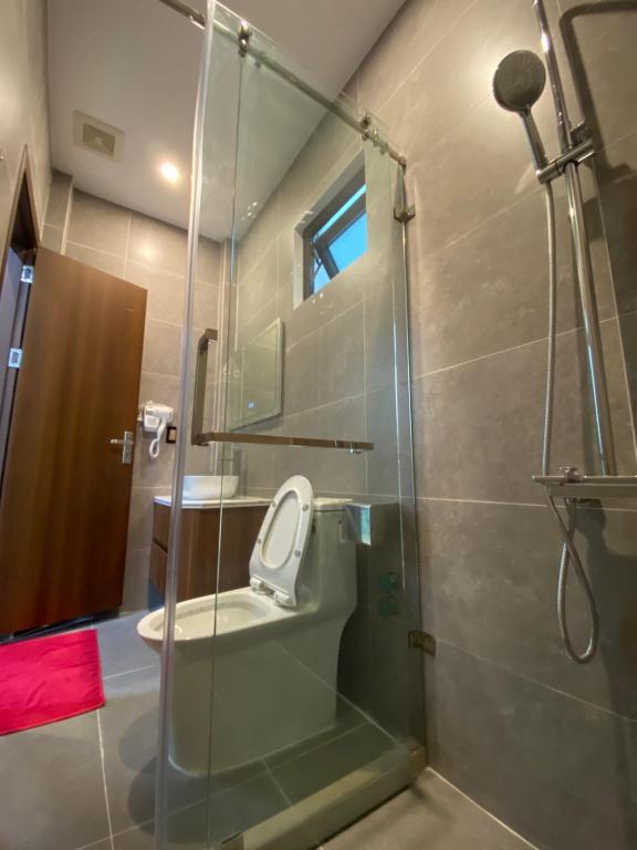 uma casa de banho com uma cabina de duche em vidro e um WC. em KIÊN NGỌC VILLA Cat Ba em Ilha de Cát Bà