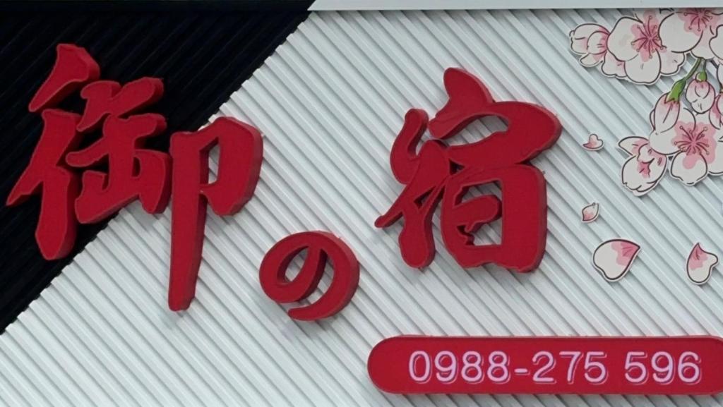 a red sign on a building with flowers on it at Royal Yado in Zhixue
