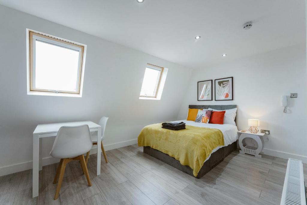 倫敦的住宿－Fulham Guest Studios 268，一间卧室配有一张床、一张书桌和一个窗户。