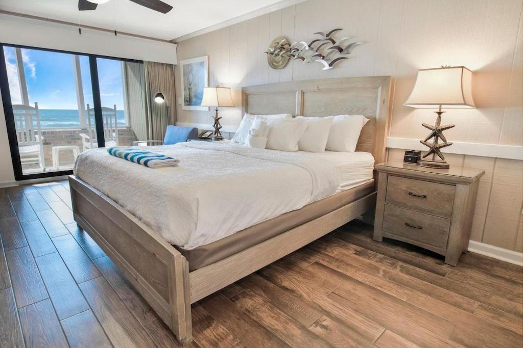 a bedroom with a large bed and a large window at Oceanfront Escape with Private Porch 1st Floor in Pawleys Island