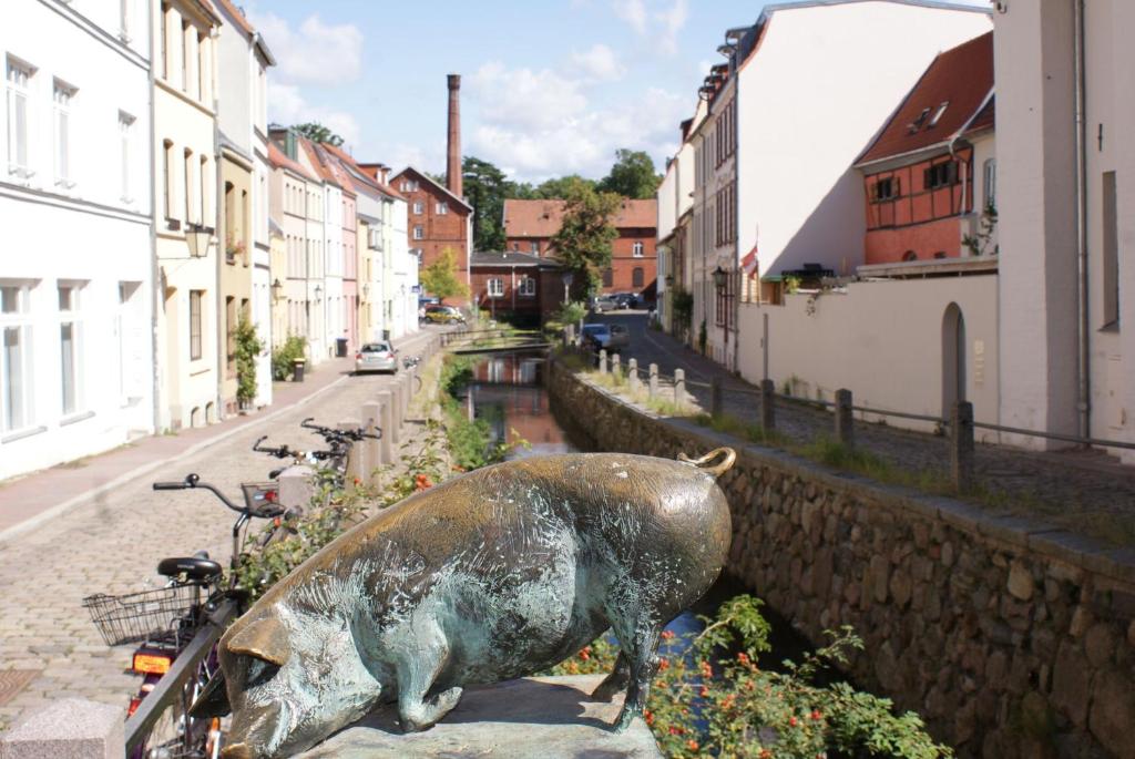 a statue of a pig on the side of a street at Bändsel Herberge Kaffetiet - ABC363 in Wismar