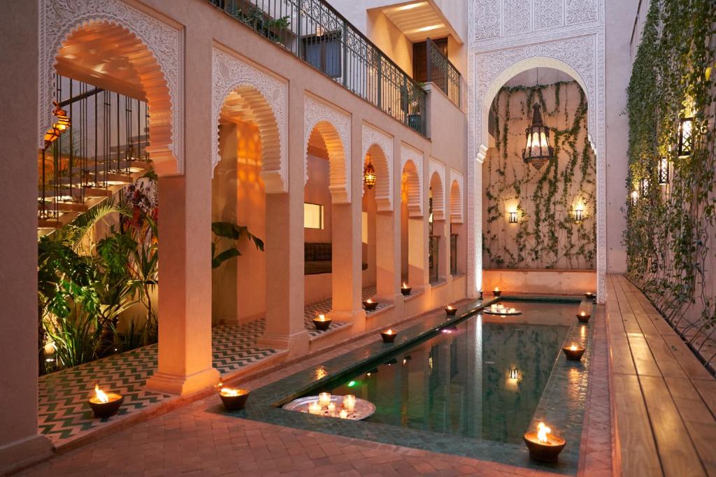 IZZA Marrakech في مراكش: مسبح في مبنى فيه انوار في الماء