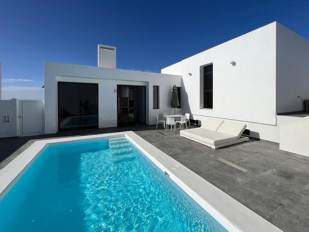 a swimming pool in front of a white house at Casa Blanca Teguise in Teguise