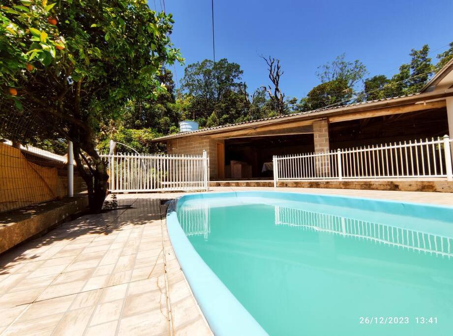 een groot blauw zwembad naast een huis bij Casa de campo, Piscina e Cristo in Encantado