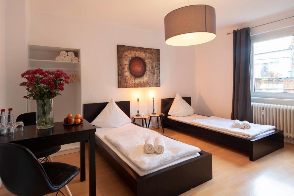 Habitación con 2 camas y mesa con velas en City Apart Hannover, en Hannover