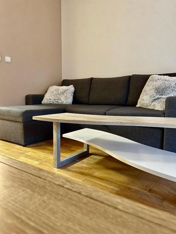 uma sala de estar com um sofá e uma mesa de centro em Zen Apartman em Budakalász