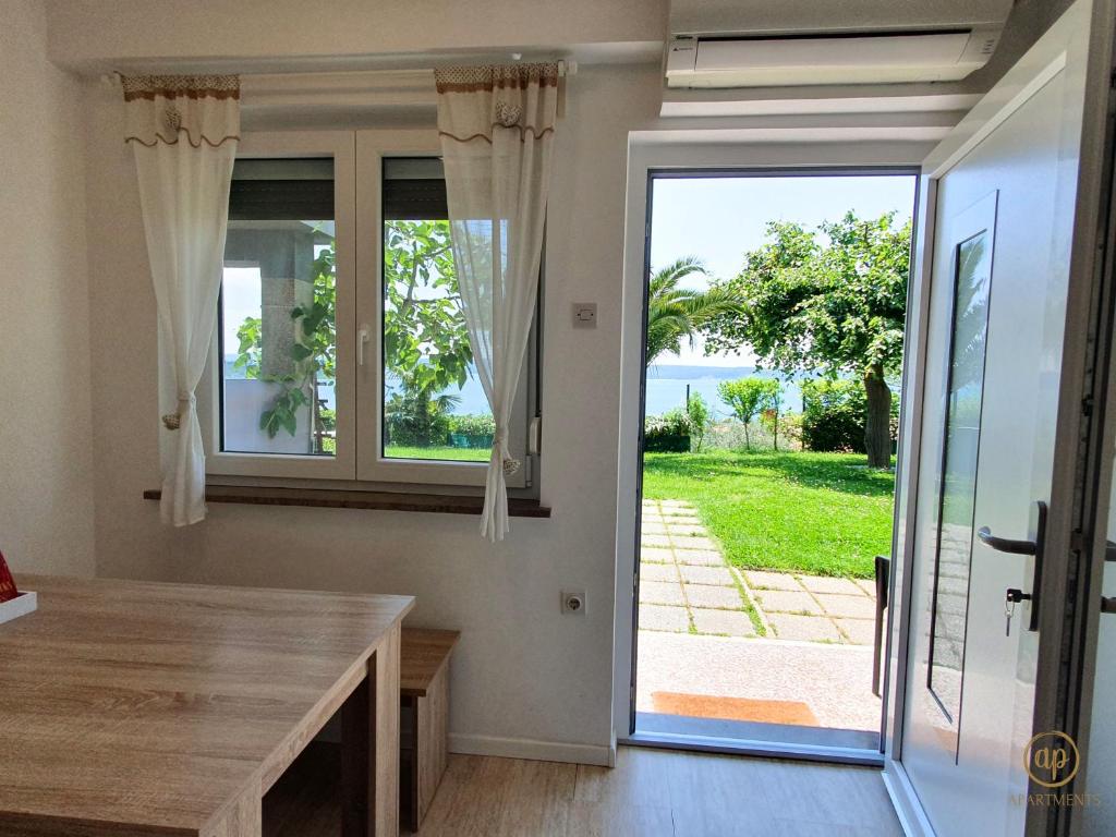 a dining room with a table and a large window at Apartment with SeaView and Garden for 6 in Portorož