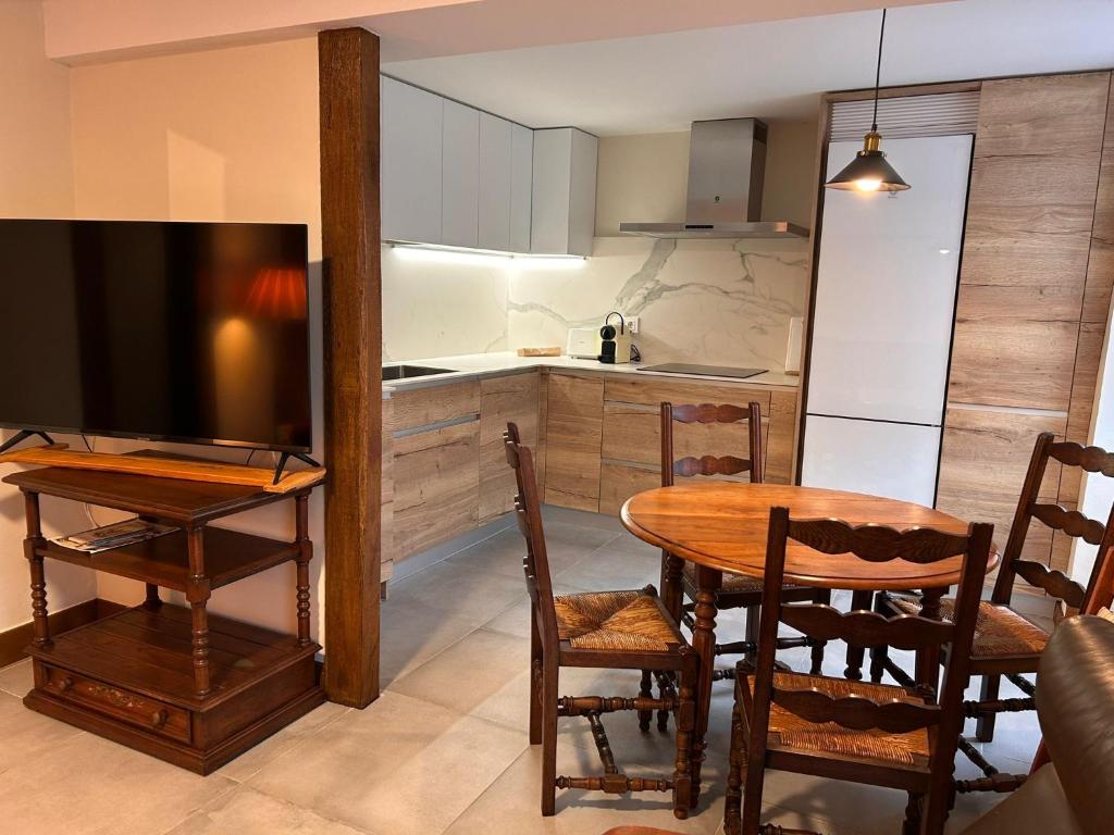 cocina y comedor con mesa y TV en Magdalenea - Apartamento, en Lesaka