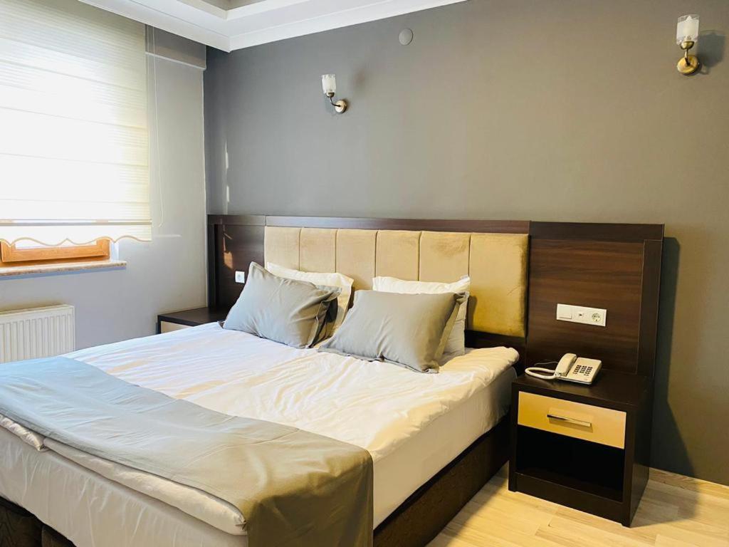 Animos Butik Otel في أنقرة: غرفة نوم بسرير كبير مع تلفون
