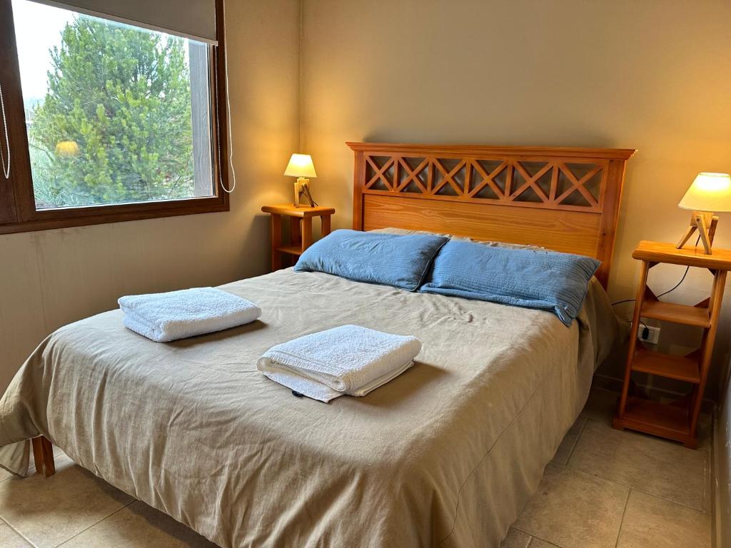 1 dormitorio con 1 cama con 2 toallas en RETAMA en San Carlos de Bariloche