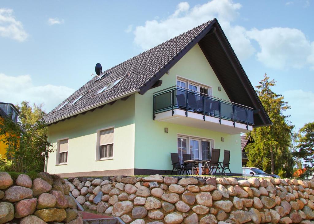 een huis met een zwart dak en een stenen muur bij Ferienwohnung Biber im Müritz Seepark in Marienfelde