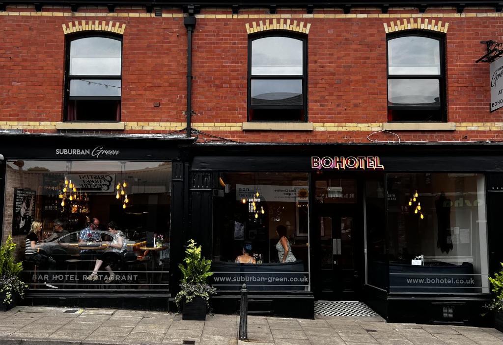 a store front of a brick building with a restaurant at BOHOSTEL in Macclesfield