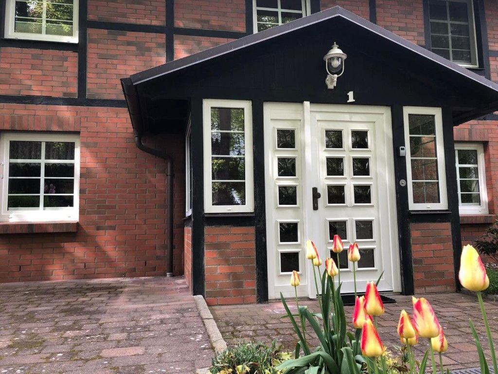 a brick house with a white door and some flowers at Ferienhaus Kirchblick - nur für Feriengäste - ABC365 in Dorf Mecklenburg