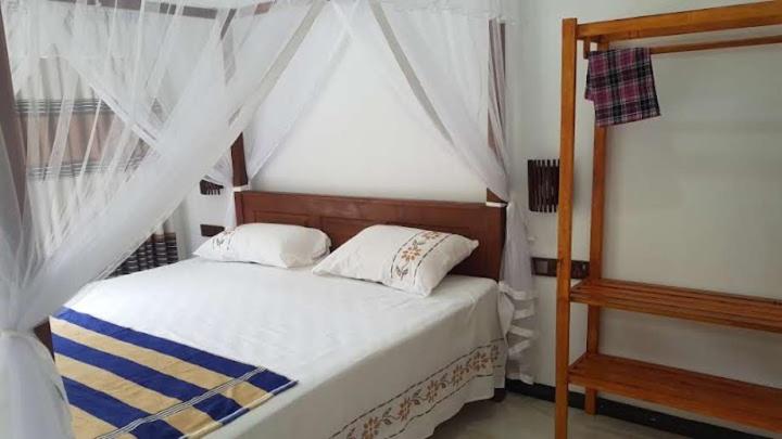 a bedroom with a bed with a canopy at Blue sky villa in Mirissa