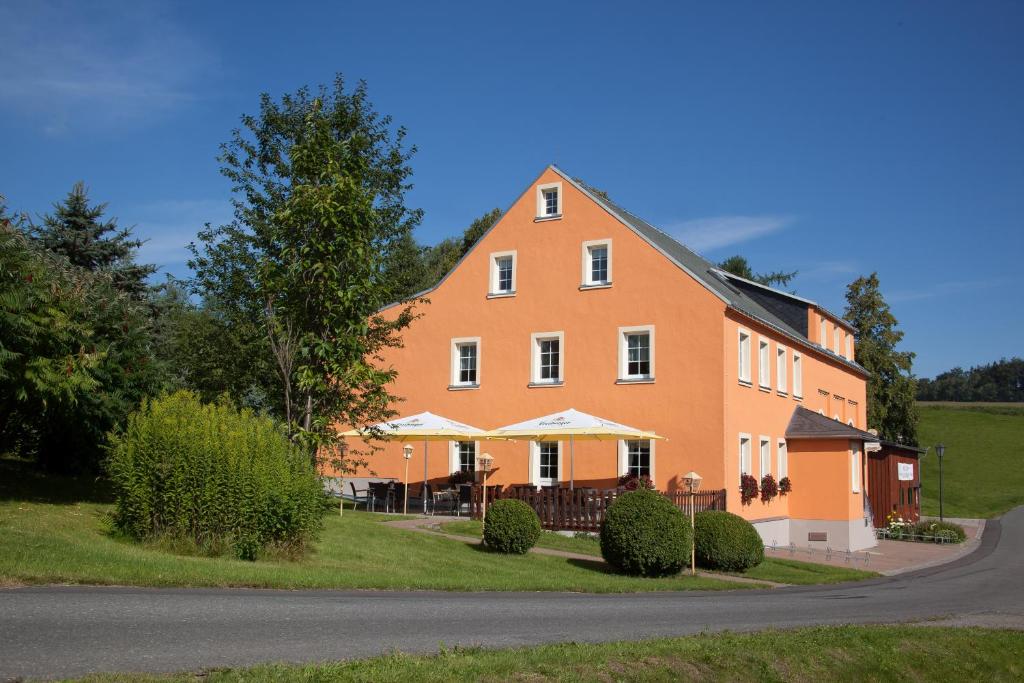 una gran casa naranja al lado de una carretera en Wolfsgrunder Festhof, en Dorfchemnitz