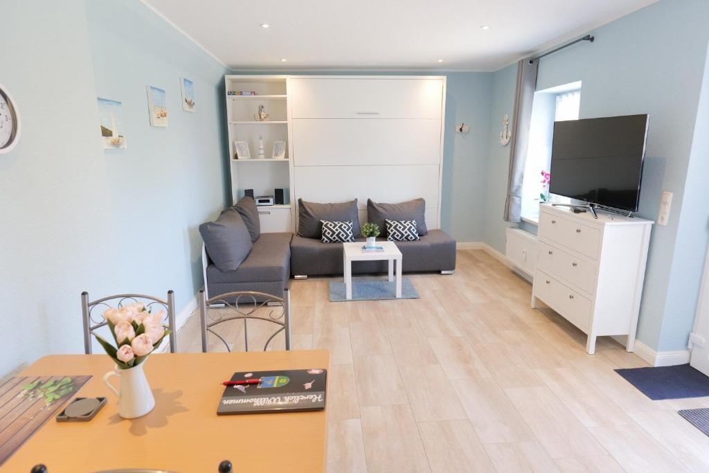 Una sala de estar con un sofá y un televisor. en FeWo Thule Poel an der Ostsee - ABC368 - nur Feriengäste!, en Kirchdorf