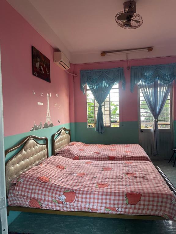a bed in a room with pink walls and windows at Huỳnh Hương Guesthouse in Ha Tien