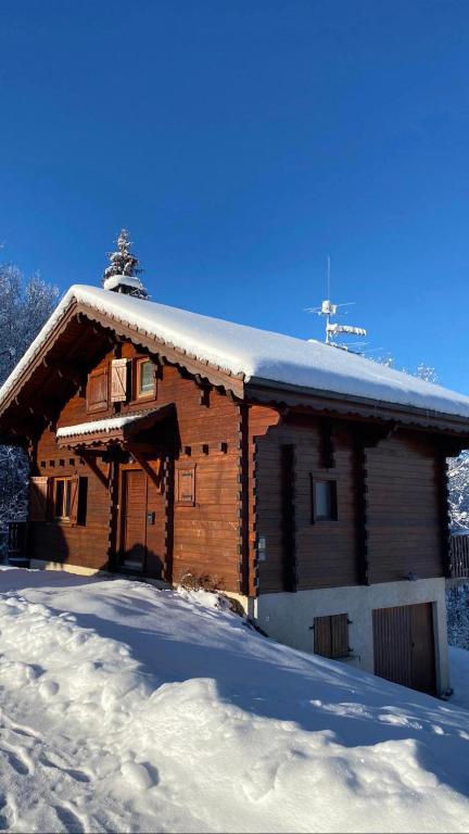 une cabane en rondins avec de la neige sur le toit dans l'établissement Chalet de charme aux Carroz d'Arrâches-Flaines, aux Carroz d'Arâches
